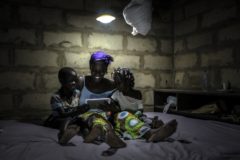african woman using baobao solar in uncompleted building